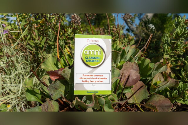 Omni Cleansing Shampoo box among green plants