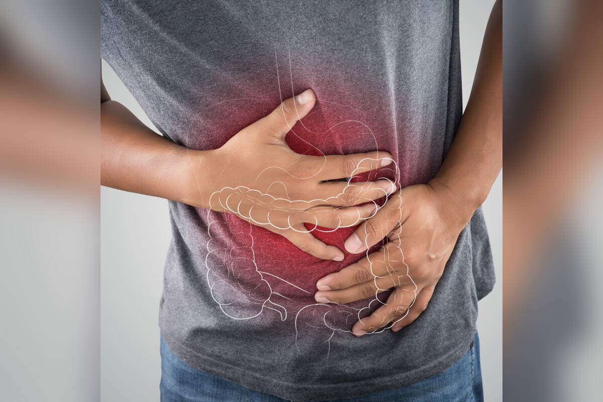 Person holding their stomach in pain with the digestive tract highlighted