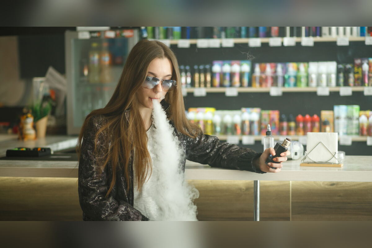 Woman exhaling vapor in a vape and smoke shop