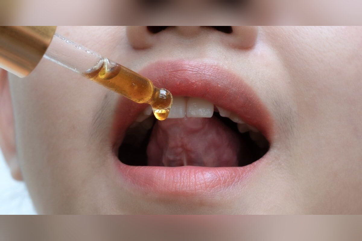 Person placing CBD oil drops under the tongue