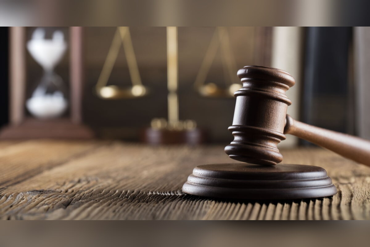 Judge's gavel on a sound block with scales and an hourglass behind
