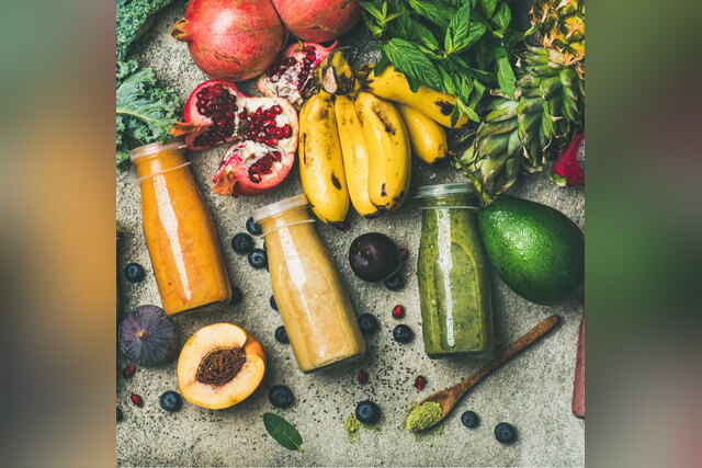 Fresh fruit, vegetables and smoothies in jars on a table