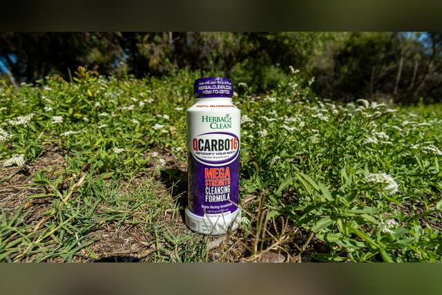 Bottle of Herbal Clean QCarbo16 Mega Cleansing Formula in a field