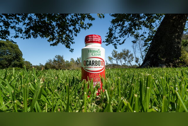 Herbal Clean QCarbo16 detox drink standing in tall grass