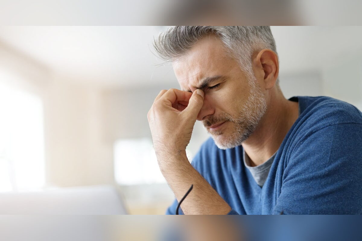 Man with a migraine rubbing the bridge of his nose