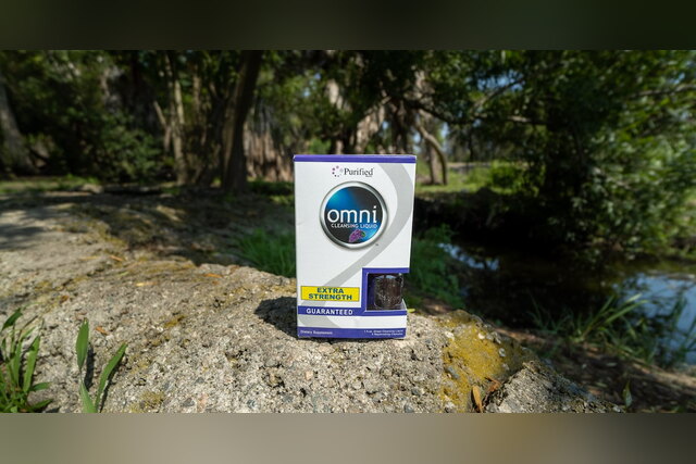 Omni Cleansing Liquid Extra Strength box on a rock by a stream