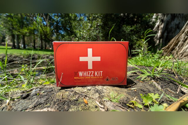Red Whizz Kit synthetic urine box on a tree stump
