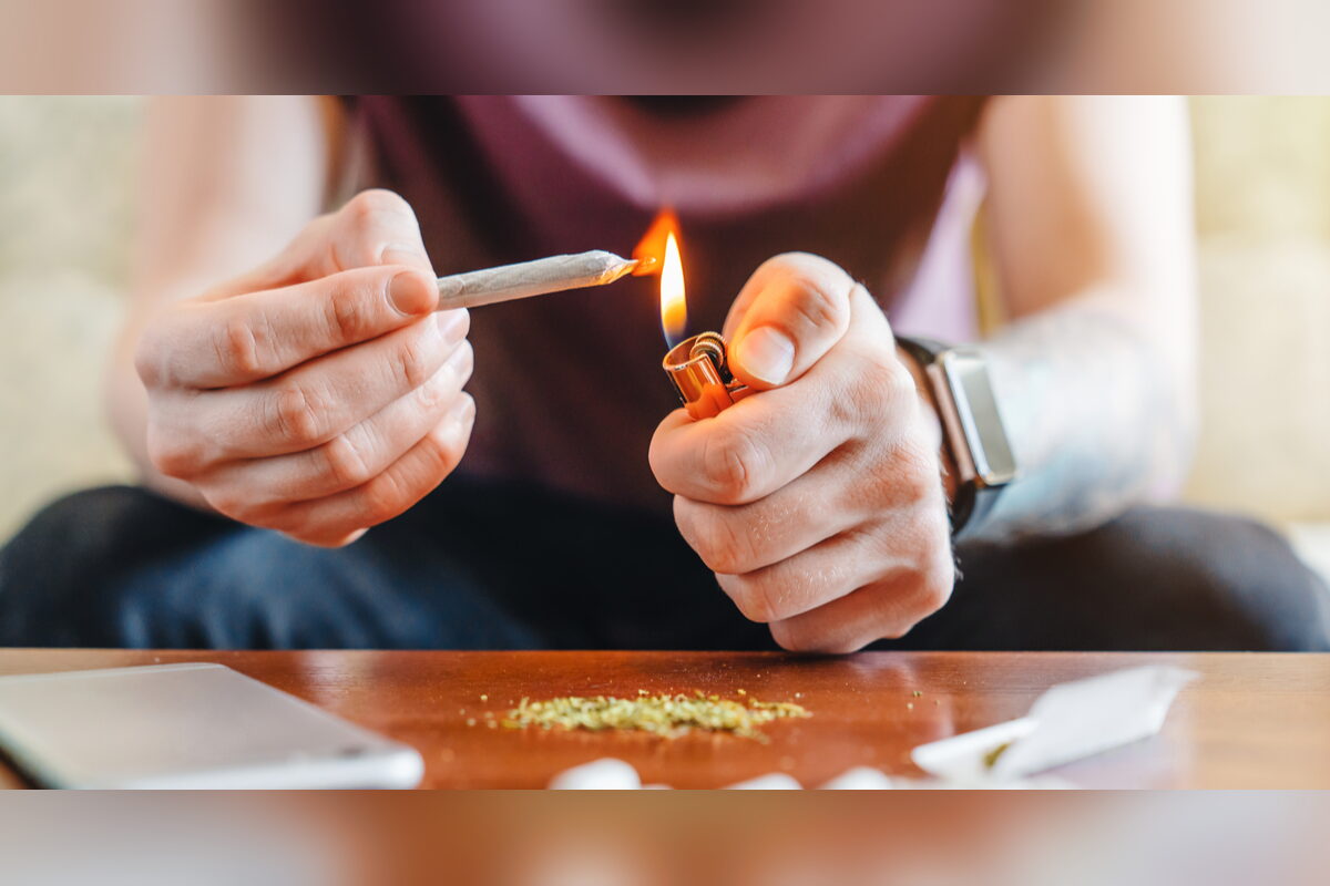 Man lighting a hemp cigarette with a lighter