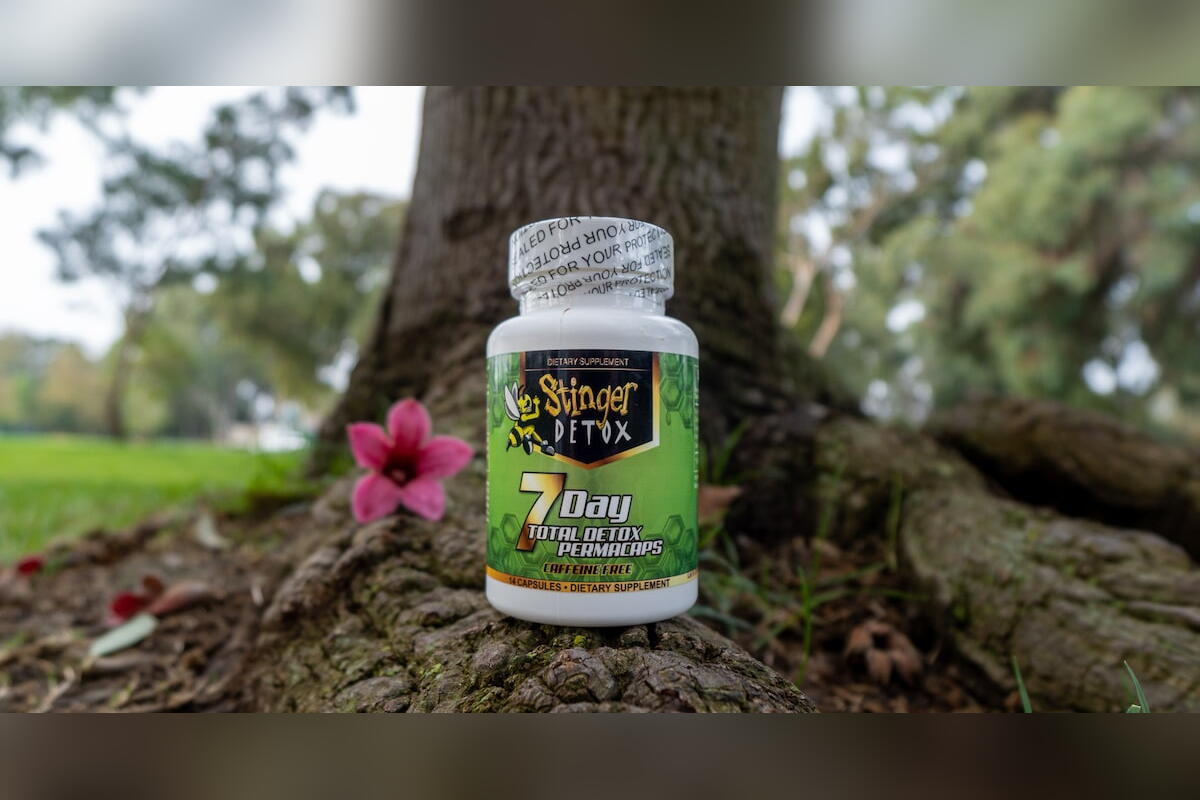 Stinger 7 Day Detox Permacaps bottle beside a pink flower